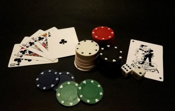 Pokerkarten und Chips liegen nebeneinander.