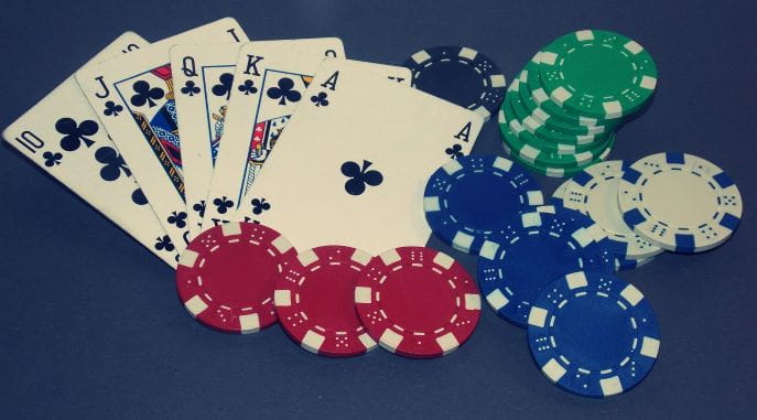 Ein Set Spielkarten und Pokerchips liegen auf dem Tisch.