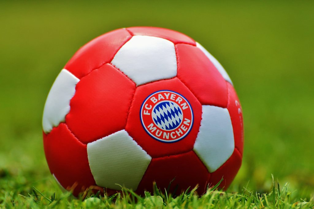 Sebuah bola sepak dengan warna FC Bayern Munich terletak di halaman.