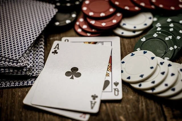 Pokerkarten und Chips liegen auf einem Tisch.