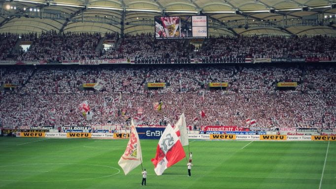 Fans jubeln bei einem Fußballspiel.