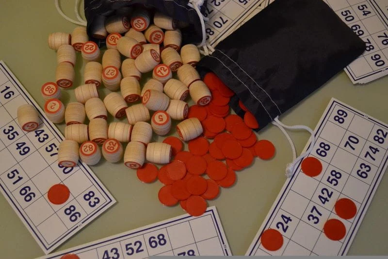 Aksesori untuk permainan bingo terletak di atas meja.