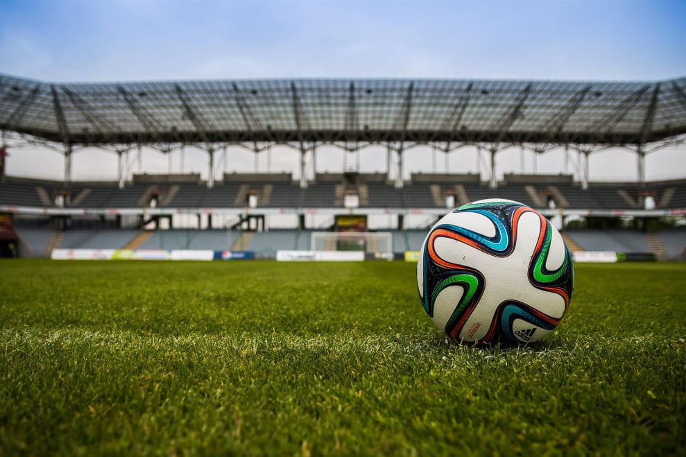 Sebuah bola sepak terletak di lapangan sepak bola.