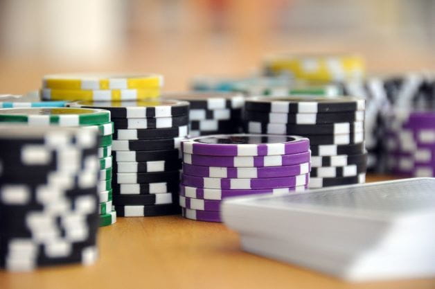 Pokerchips und Karten liegen auf einem Tisch.