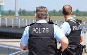 Zwei Polizisten beobachten einen Einsatz.