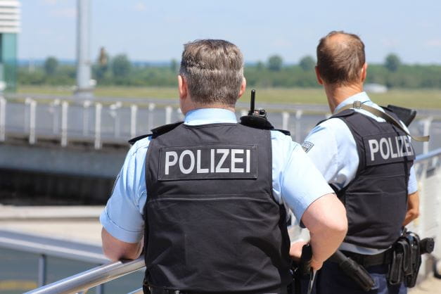 Zwei Polizisten beobachten einen Einsatz.