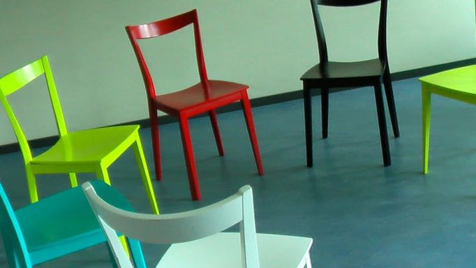 Leere Stühle stehen im Kreis angeordnet.