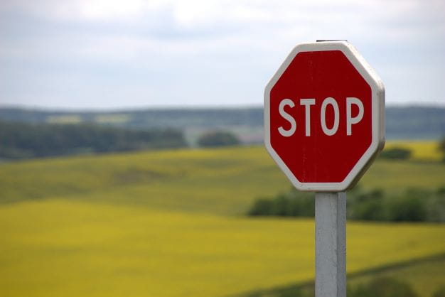 Ein Stoppschild steht vor einer Landschaft.