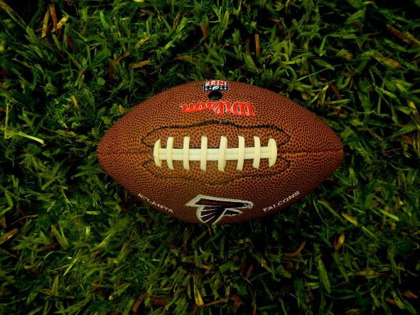 Ein American Football-Ball liegt im Gras.