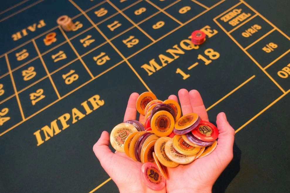 Seseorang memegang chip pemenang di kasino.