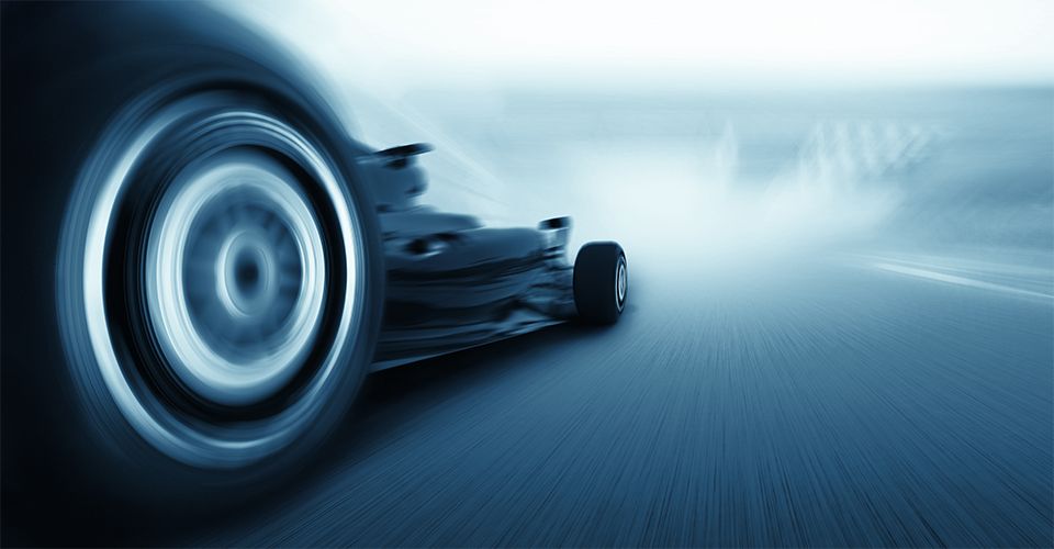 Sebuah mobil Formula 1 melaju di arena pacuan kuda.