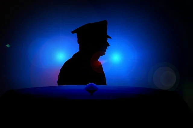 Ein Polizist steht im Blaulicht.