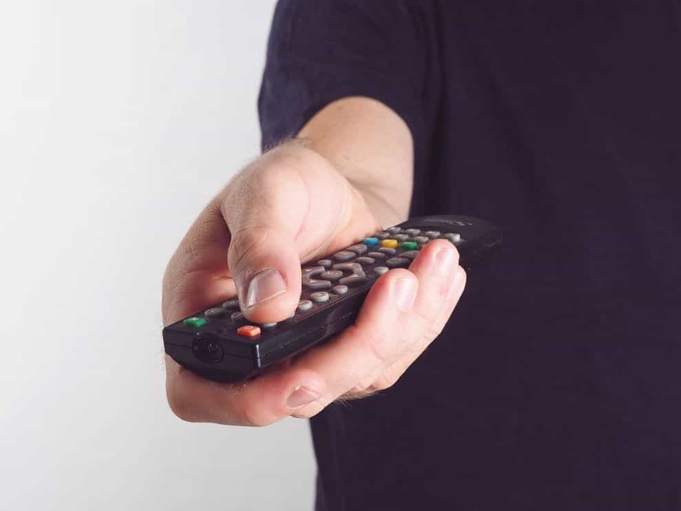 Seseorang memegang remote control.
