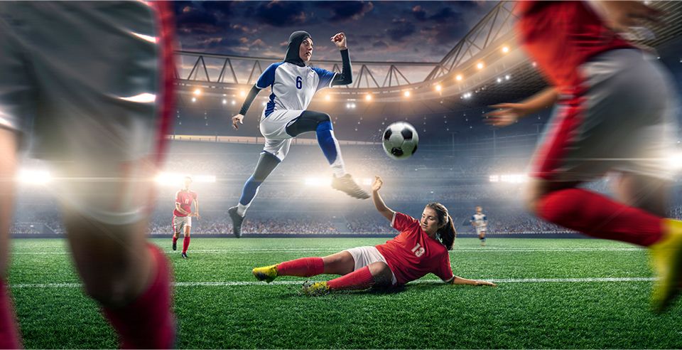 Dua pemain sepak bola berjuang untuk bola.