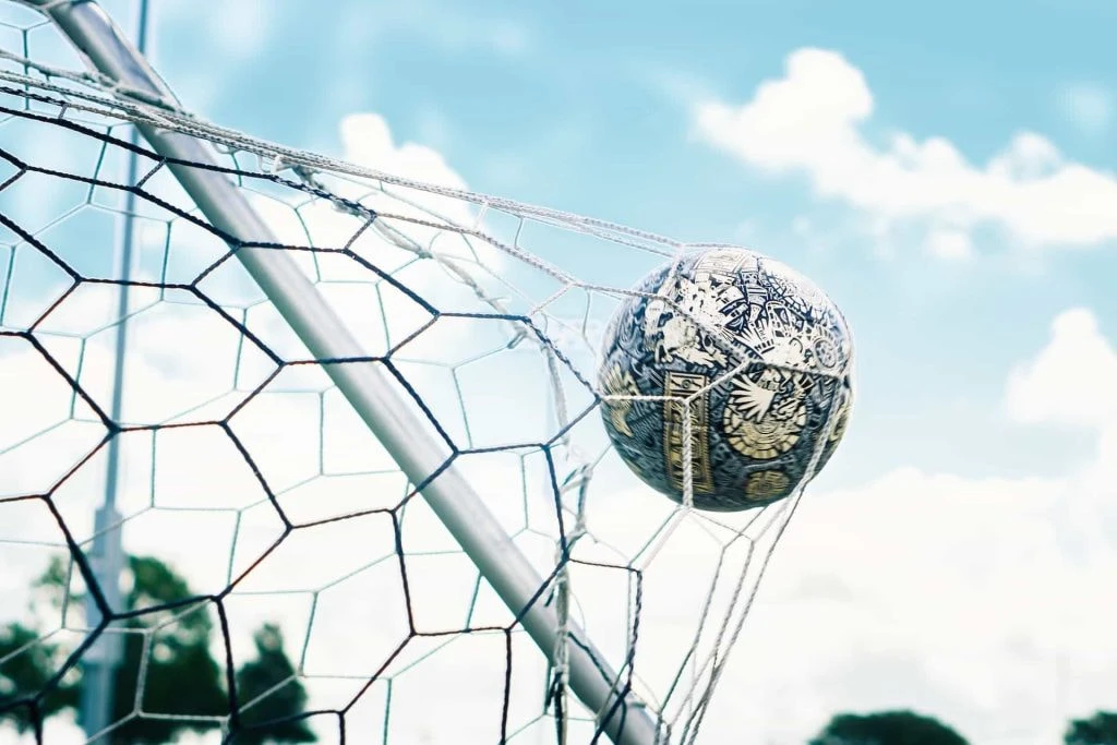 Ball schlägt im Netz eines Fußballtores ein