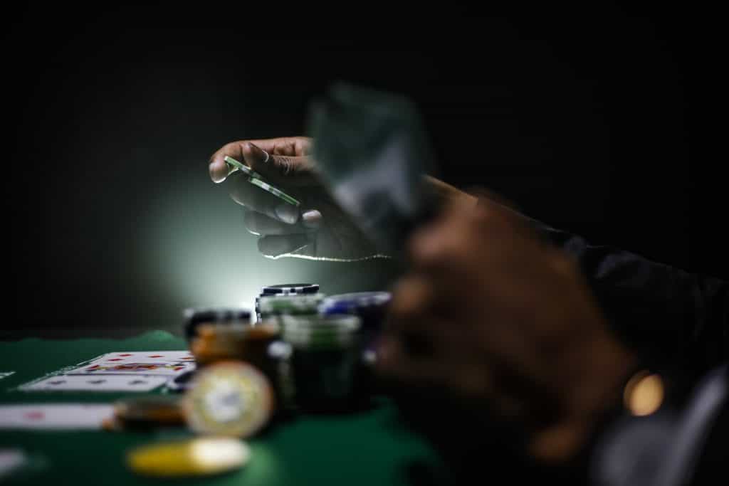 Mann spiel Poker und tätigt Einsätze