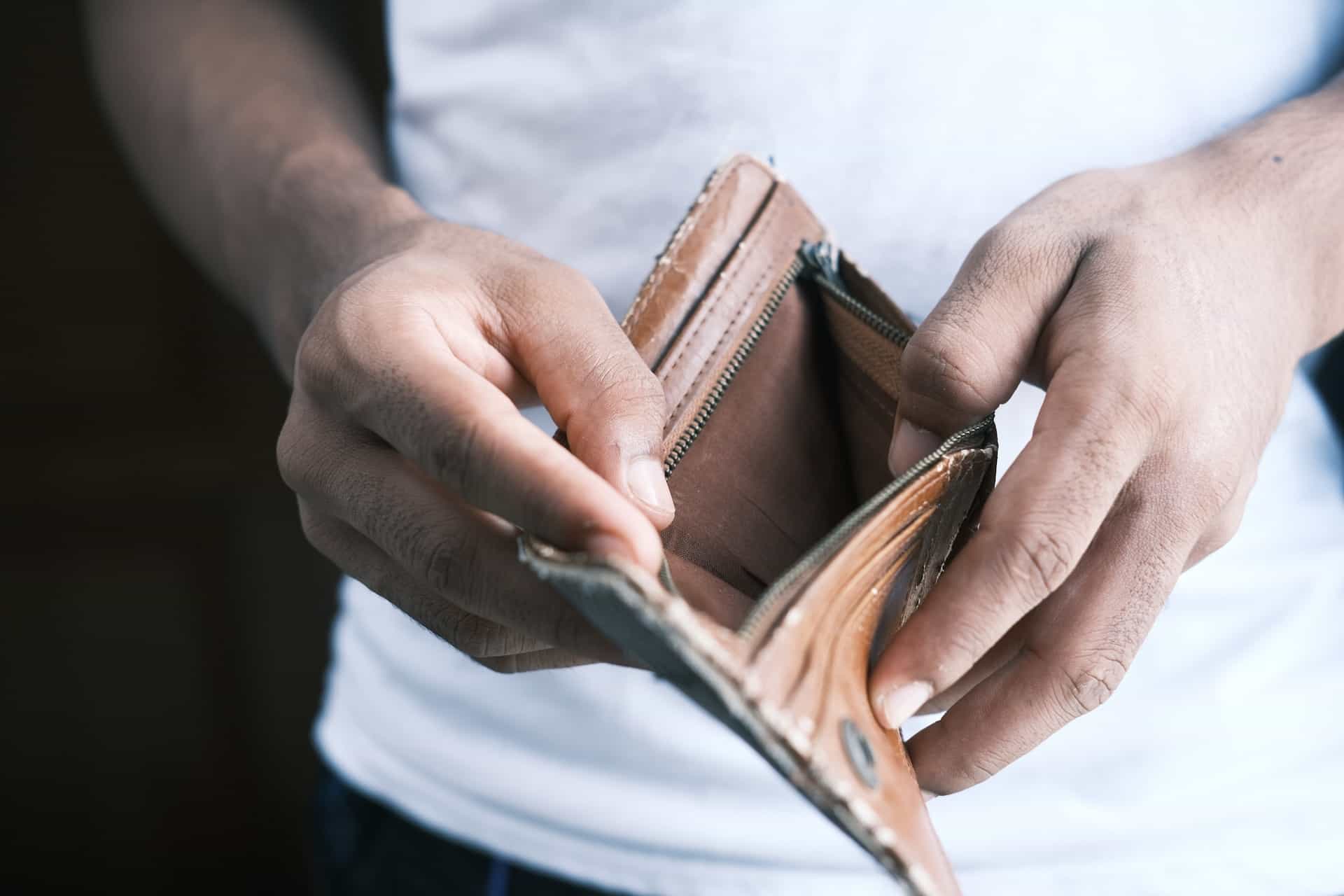 Ein Mann hält ein leeres Portemonnaie in der Hand