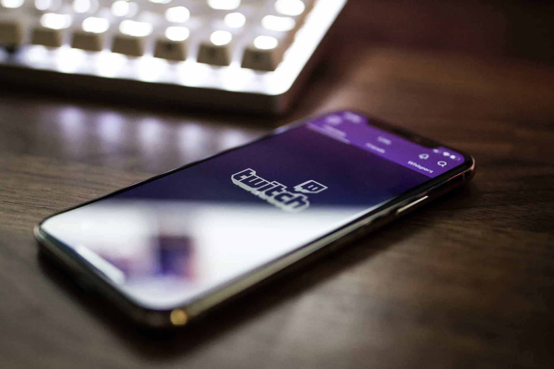 Ponsel cerdas, yang sedang memuat aplikasi Twitch, terletak di atas meja