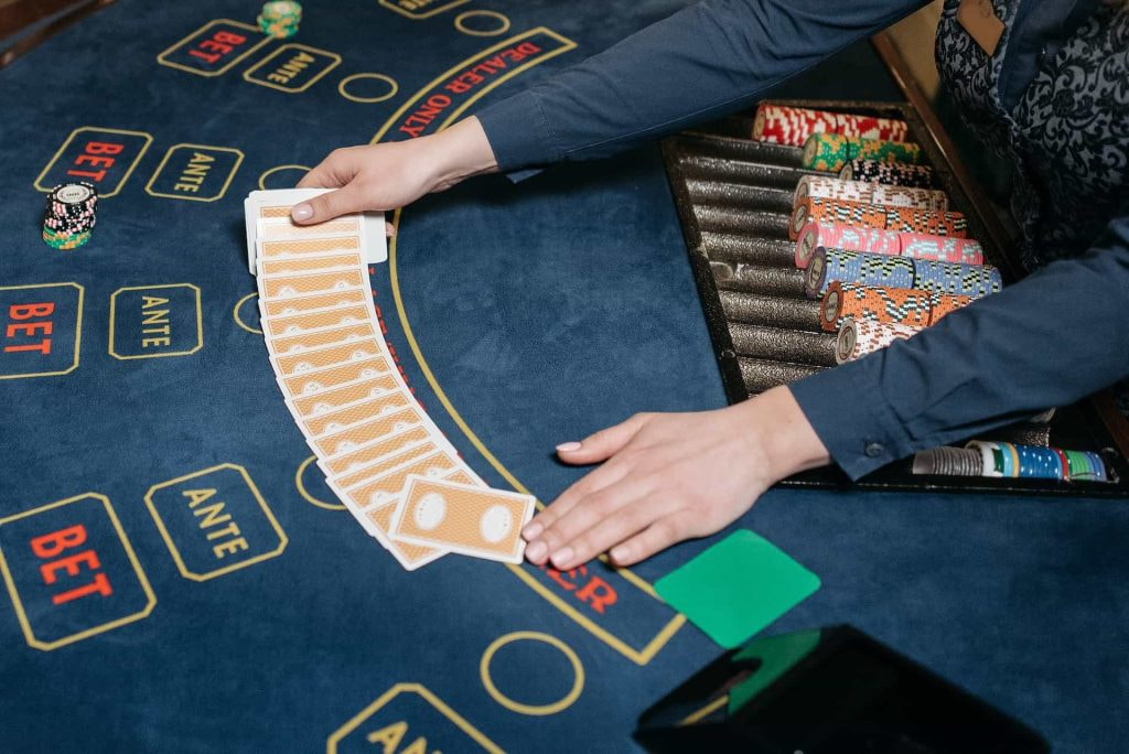 Eine Dealerin im Casino breitet Karten auf einem Spieltisch aus