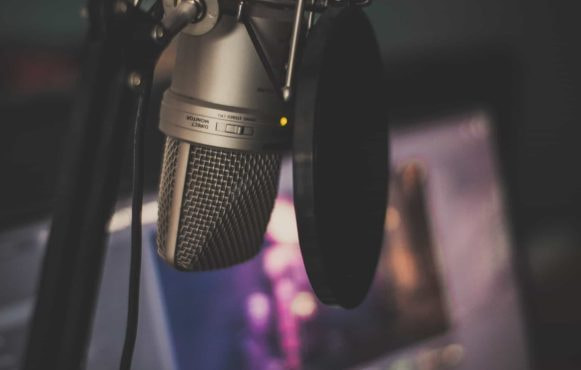 Ein Mikrofon und ein Computerbildschirm im Hintergrund