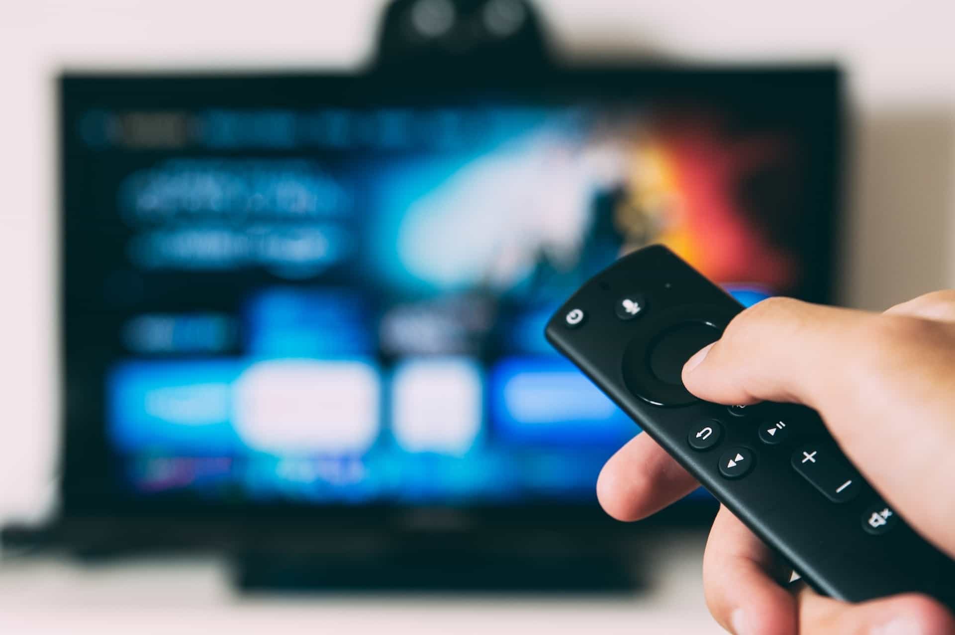 Remote control dengan televisi di latar belakang