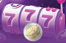 Die Walzen eines Slots mit einer 2 Euro Münze davor.