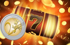 Die Walzen eines Slots mit einer 2 Euro Münze davor.