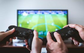 Zwei Spieler spielen ein Fußball-Videospiel am Fernseher