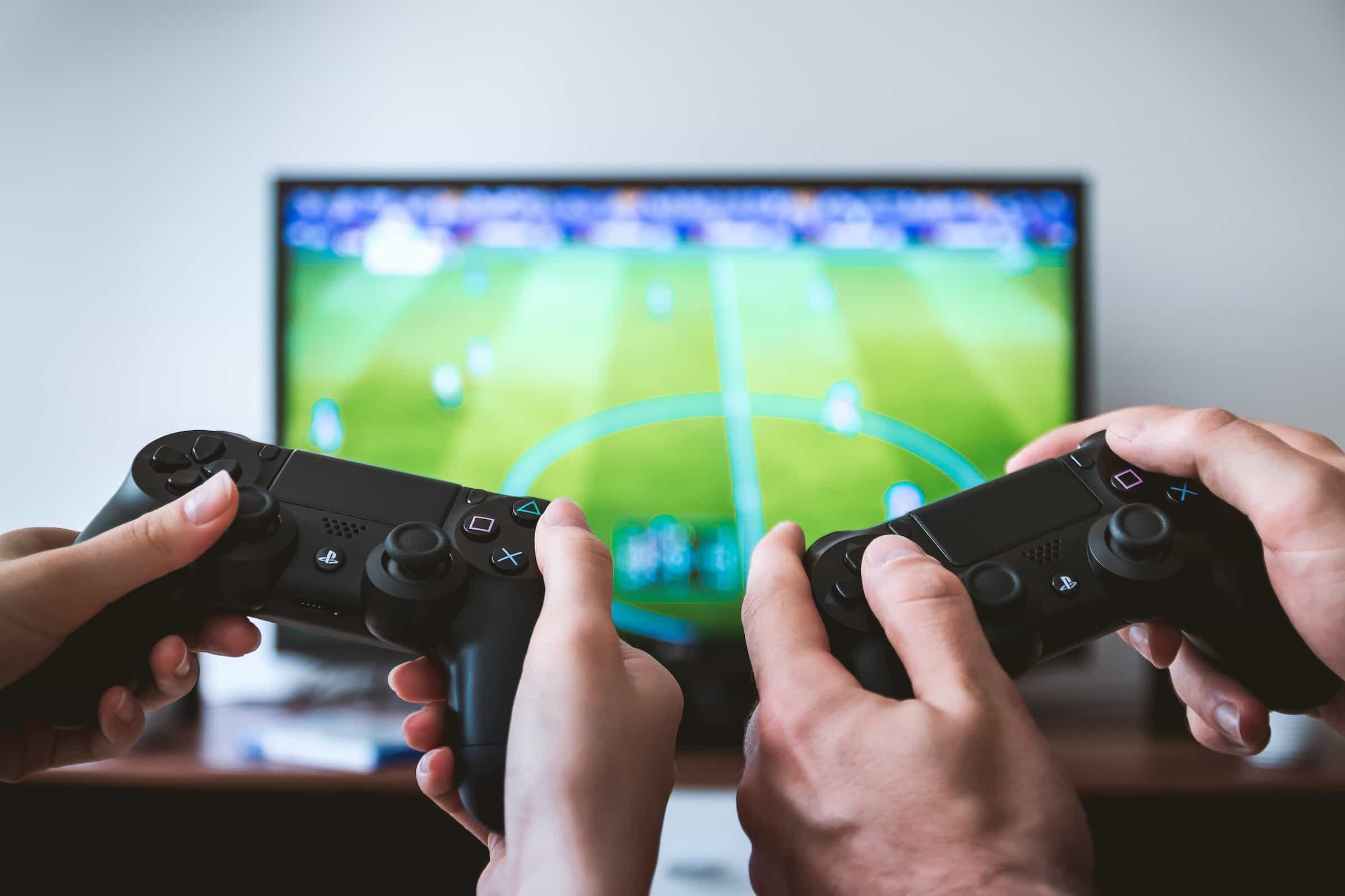 Zwei Spieler spielen ein Fußball-Videospiel am Fernseher