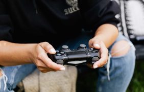 Ein Mann hält einen PlayStation-Controller in der Hand
