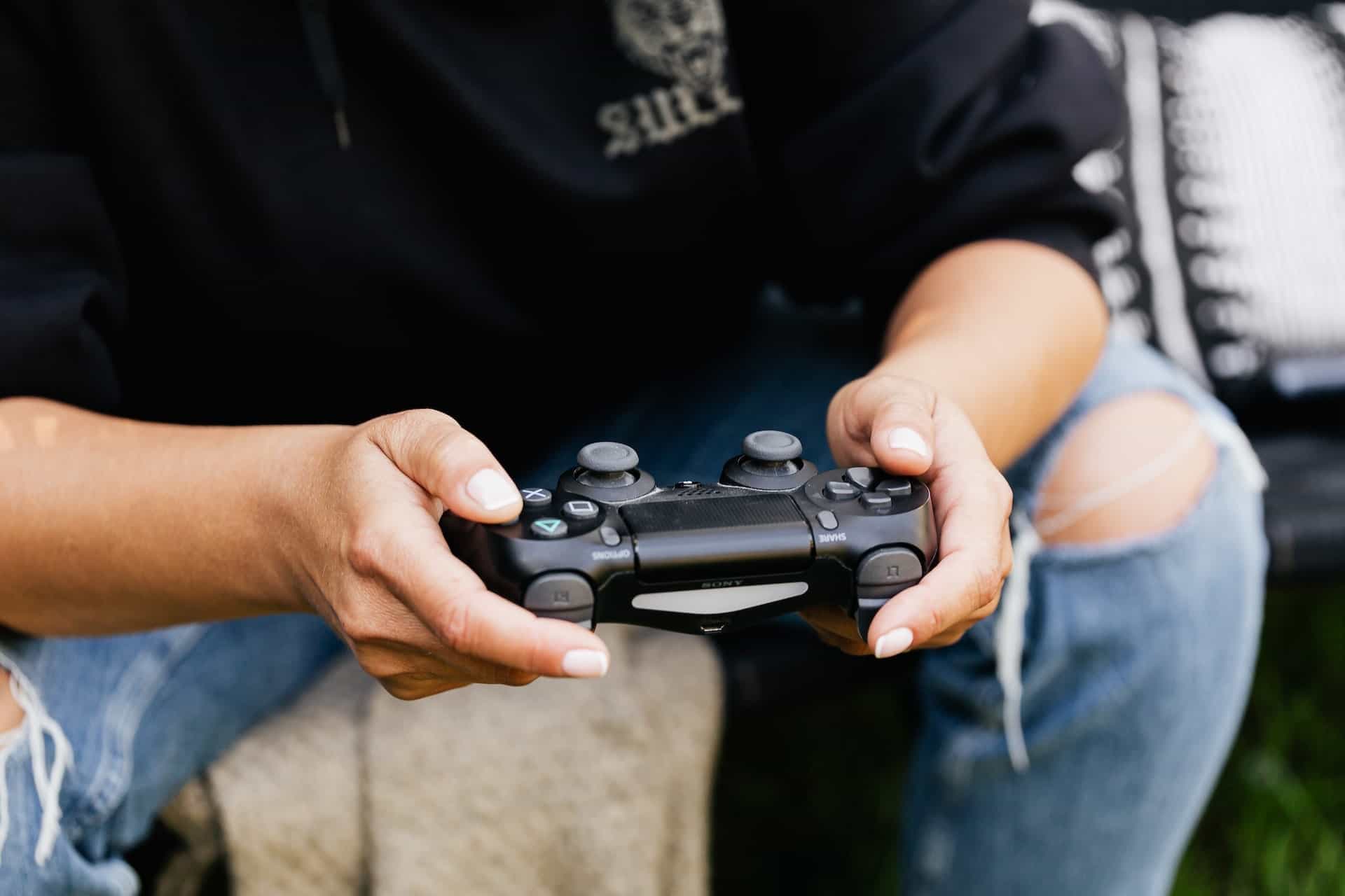 Ein Mann hält einen PlayStation-Controller in der Hand