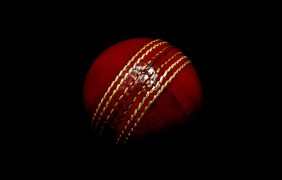 Roter Cricket-Ball auf dunklem Hintergrund