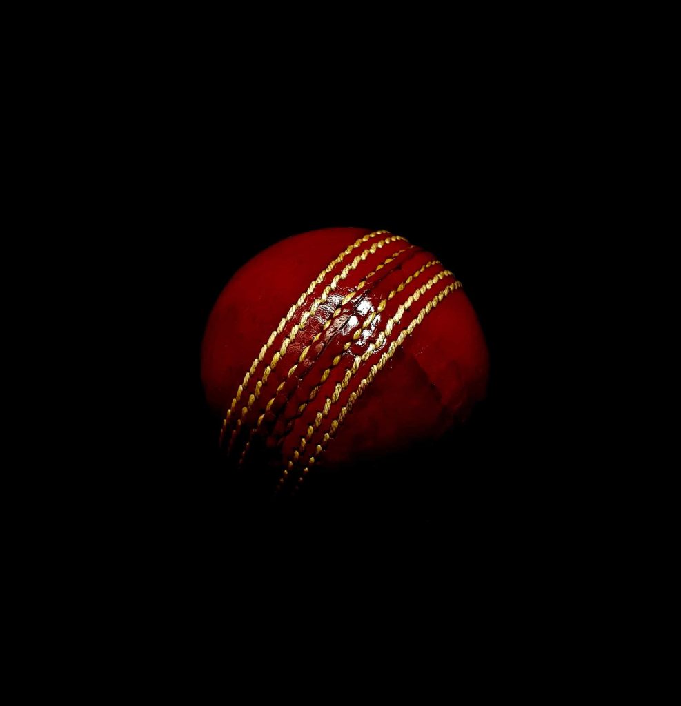 Roter Cricket-Ball auf dunklem Hintergrund