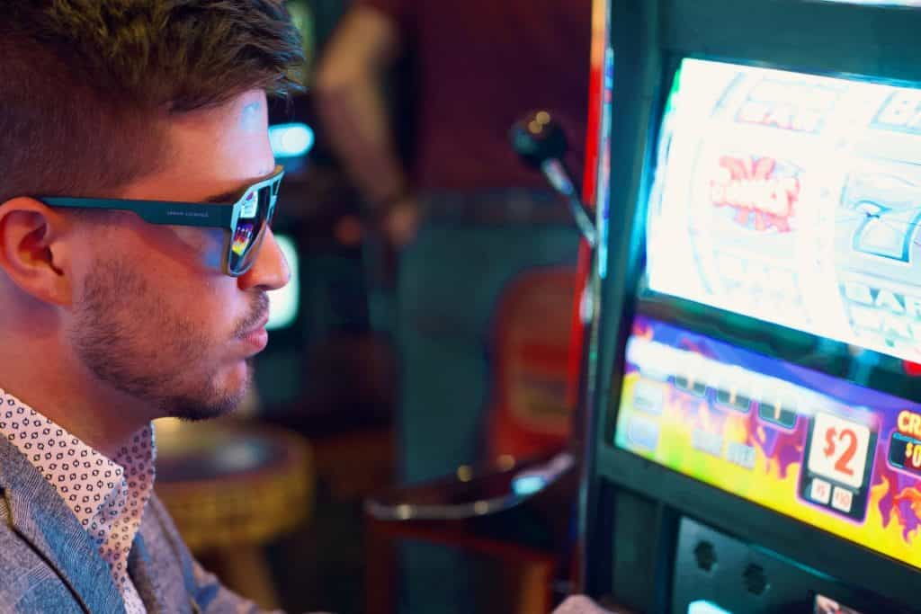 Ein Mann mit Sonnenbrille spielt an den Slots