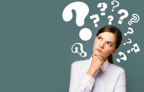 Aufnahme einer verwirrt aussehenden Frau mit Fragezeichen um ihren Kopf.