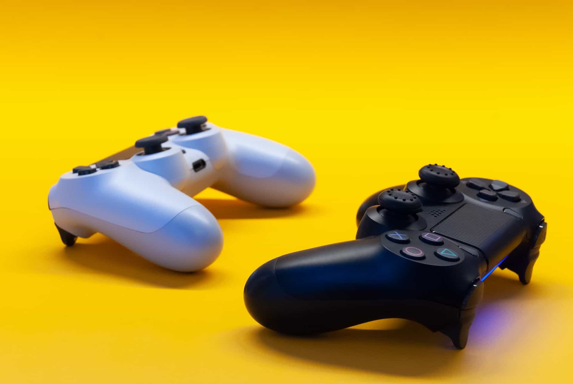 Zwei PlayStation-Controller auf gelbem Hintergrund