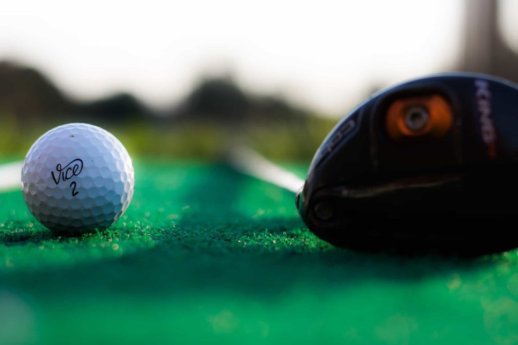 Golfball und Golfschläger auf dem Green
