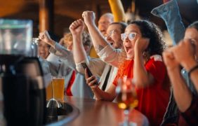 Jubelnde Menschen an einem Tisch.