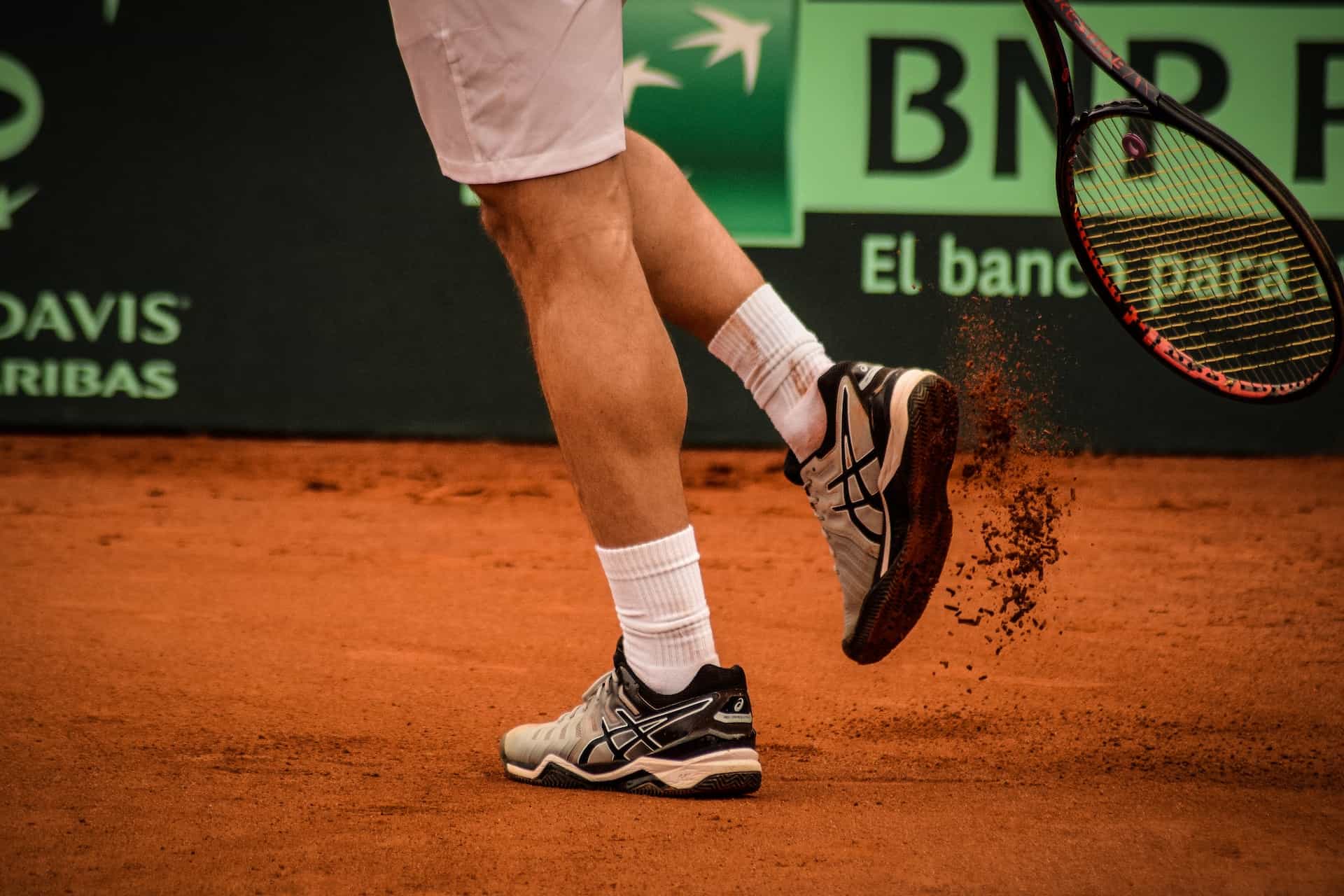 Ein Tennisprofi klopft sich den Sand aus den Schuhen