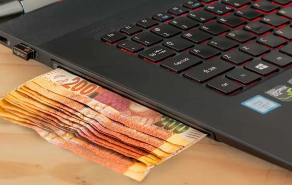 Laptop mit Geldscheinen