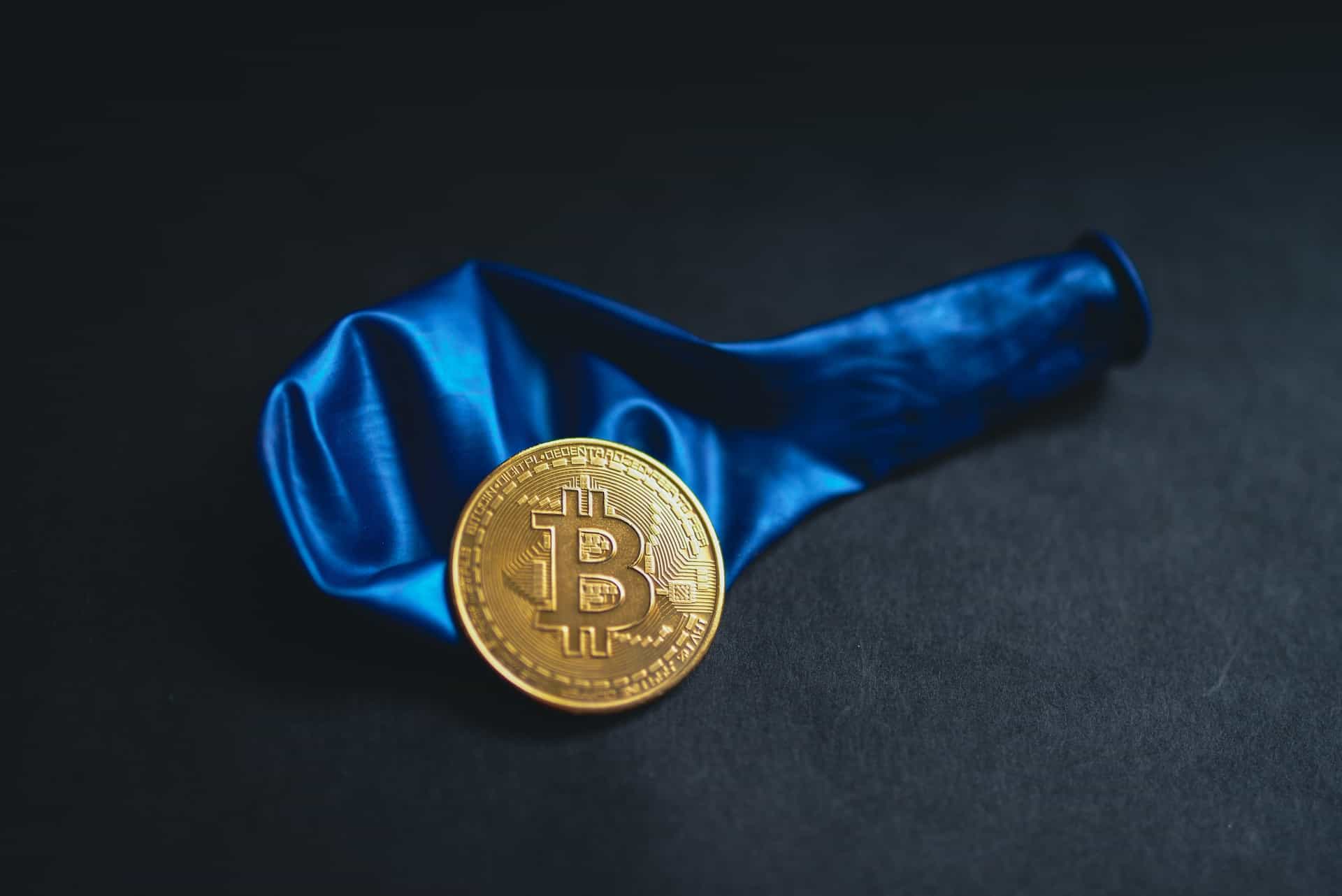 Ein luftleerer Luftballon mit einer Bitcoin-Münze