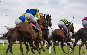 Pferde und Jockeys auf der Rennbahn