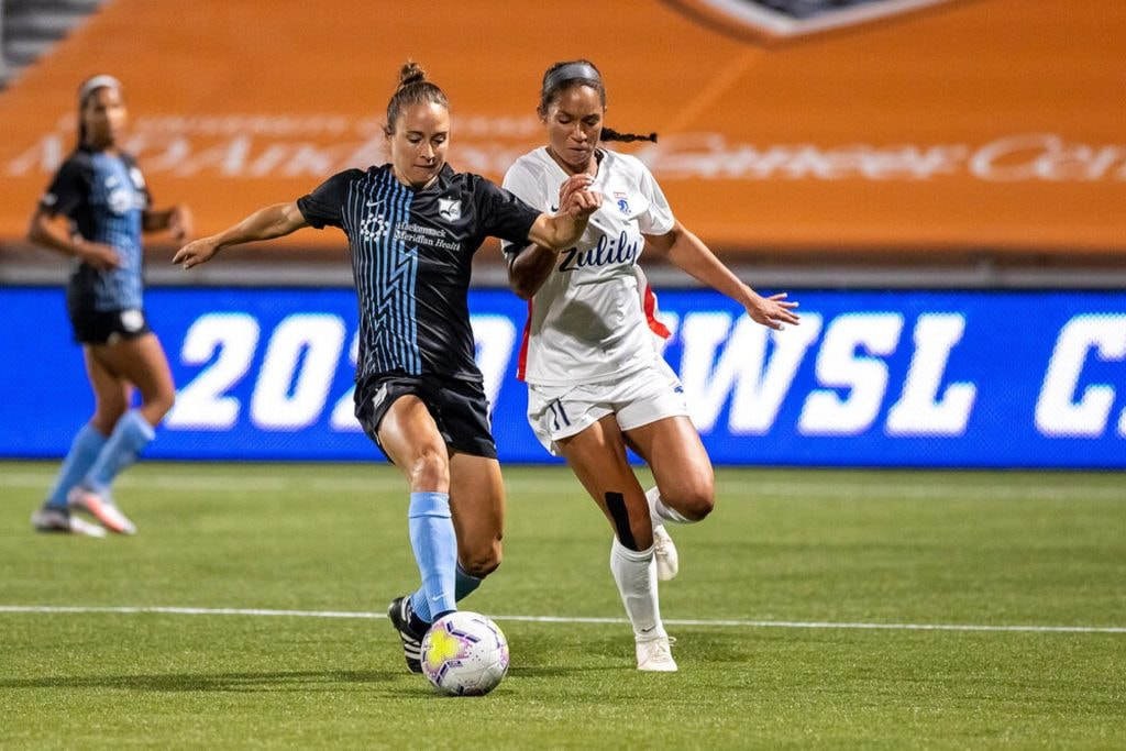 Zwei Frauen kämpfen bei einem Fußballspiel um den Ball.