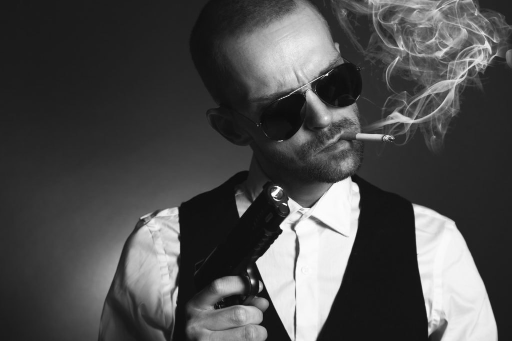 Rauchender Mann mit Sonnenbrille und Pistole in der Hand 