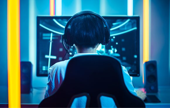 Ein Jugendlicher sitzt vor seinem Computer und ruft eine Website auf.