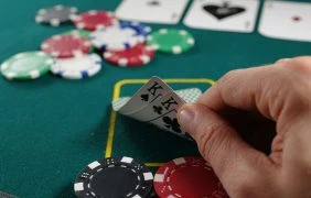Pokerkarten und Pokerchips auf Pokertisch.