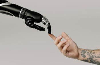 Roboterhand und menschliche Hand berühren sich.