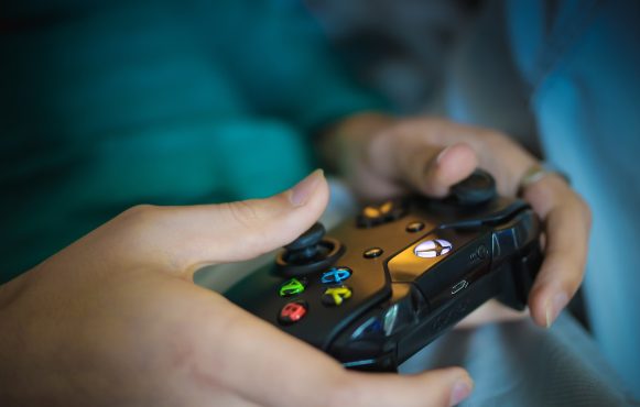Aufnahme einer Person, die einen Controller in der Hand hält.