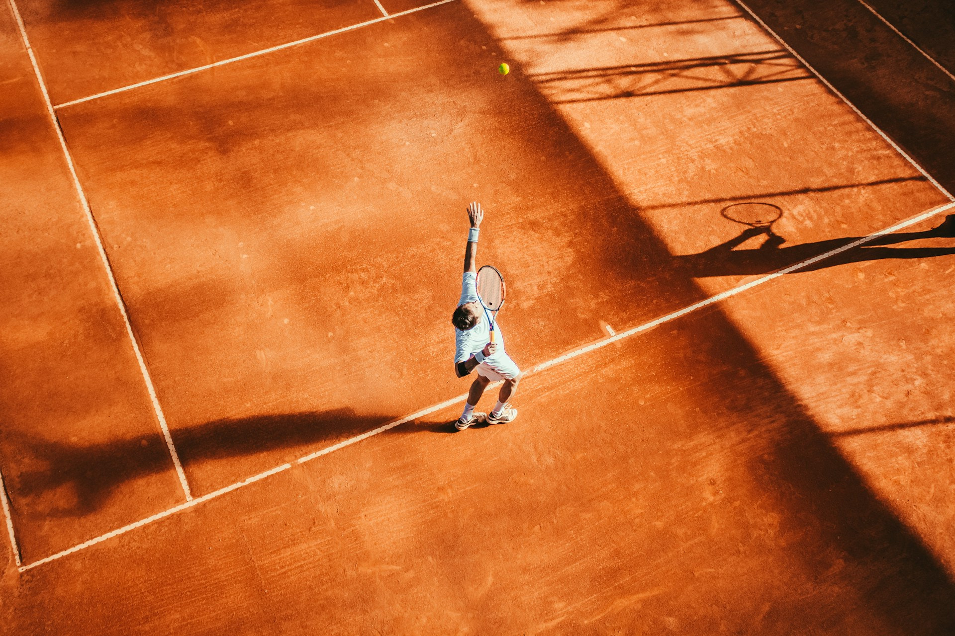 Ein Tennisspieler beim Aufschlag auf einem Tennisplatz