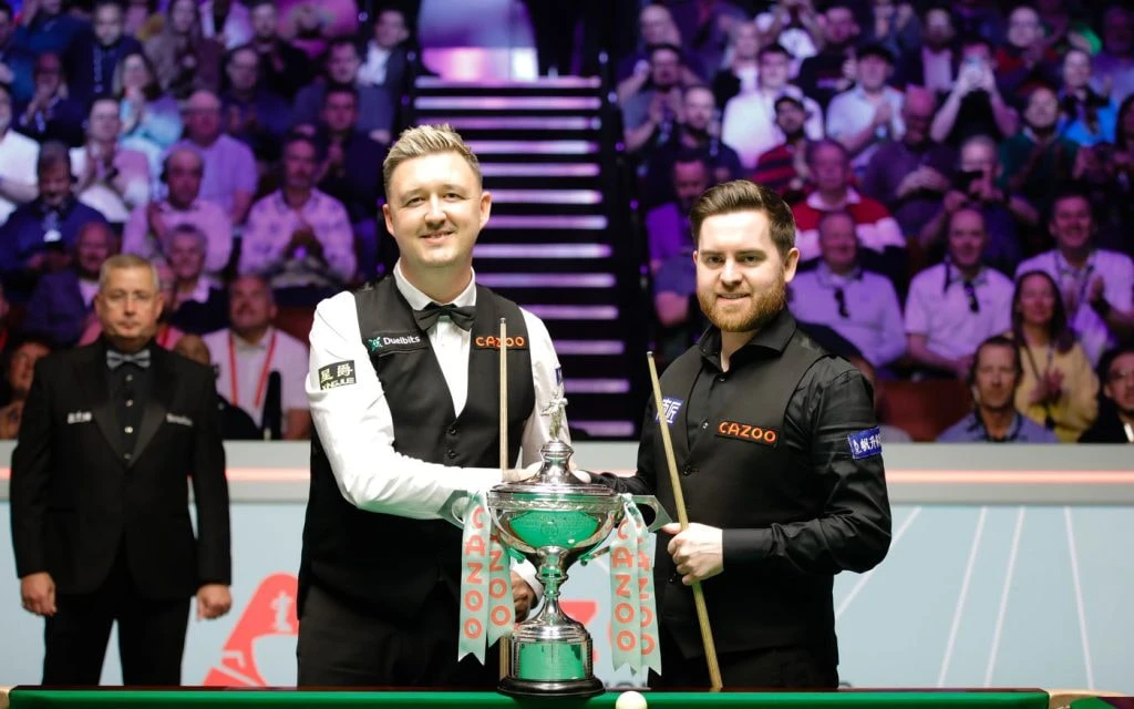 Aufnahme von Kyren Wilson und Jak Jones mit dem Pokal der Snooker-Weltmeisterschaft.
